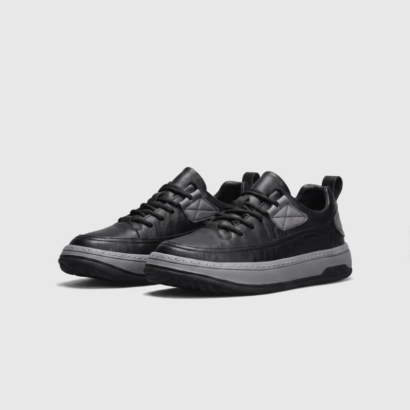 chunky sole leather casual sneakers in black, front 45-degree view of the pair on a light gray background
