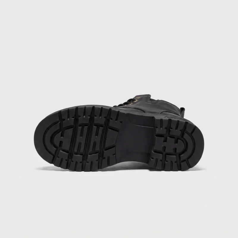chunky sole leather ankle boots in black, outsole tread view on a light gray background
