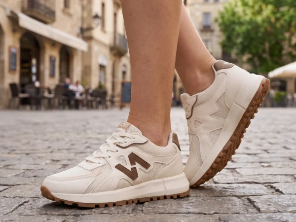 chunky platform running sneakers breathable mesh lightweight soft sole everyday casual shoes in blue, worn on foot on a old-town square, soft daylight lifestyle photo