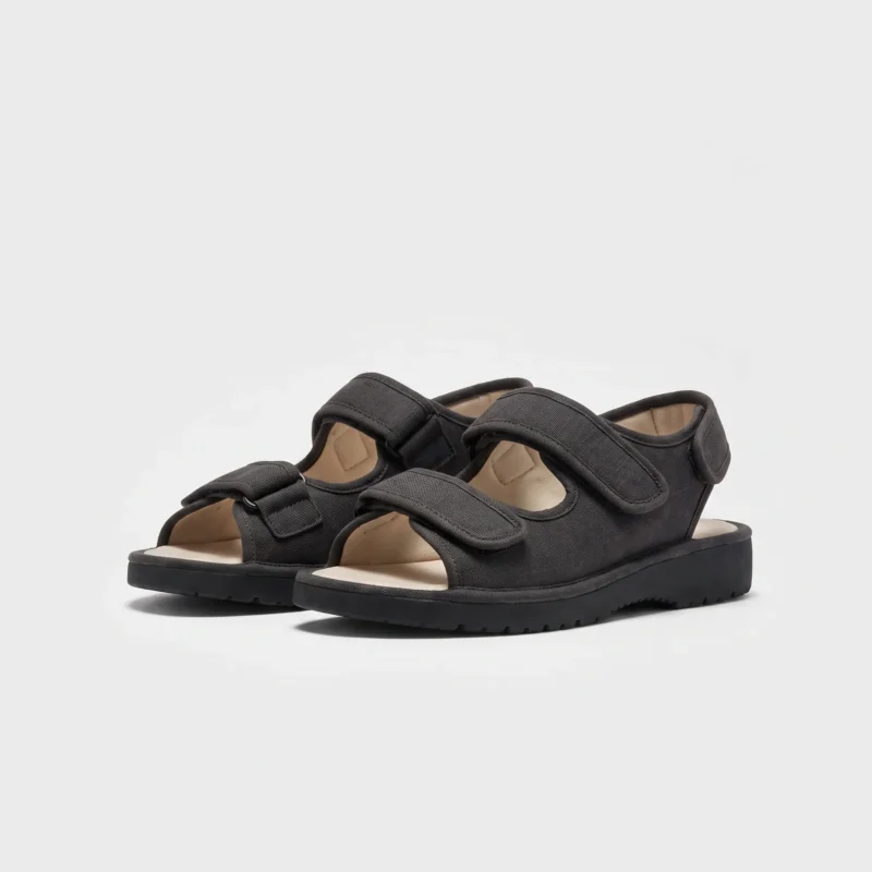 Pair of black AZEKA adjustable strap linen sandals, front 45 degree view, thick cushioned sole on light gray background
