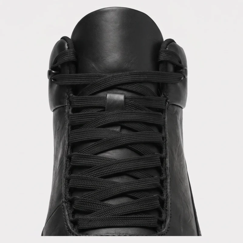 Woven lace and tongue detail of the black high-top leather boots