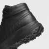 Heel and anti-slip rubber outsole detail of the black high-top leather boots