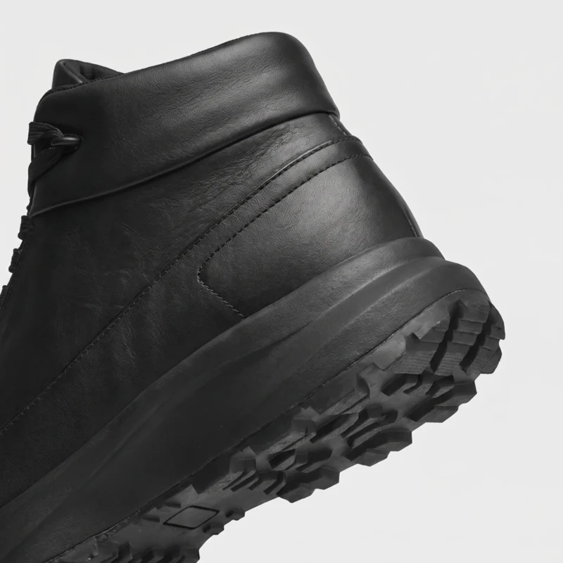 Heel and anti-slip rubber outsole detail of the black high-top leather boots