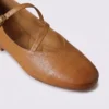 Close-up of the rounded almond toe and crossed instep strap of apricot AZEKA Mary Jane flats