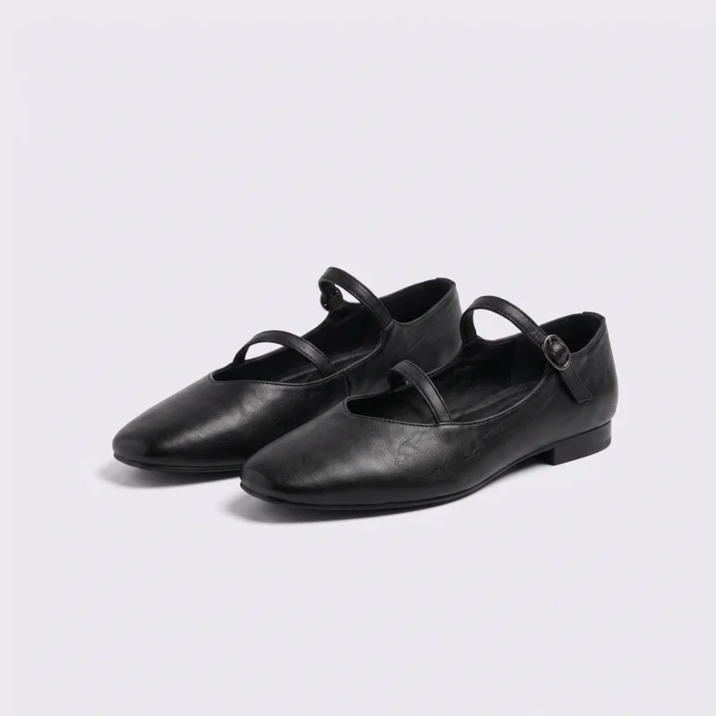 Pair of black AZEKA French-retro single-strap Mary Jane flats, soft flat sole, front 45 degree view on light gray background