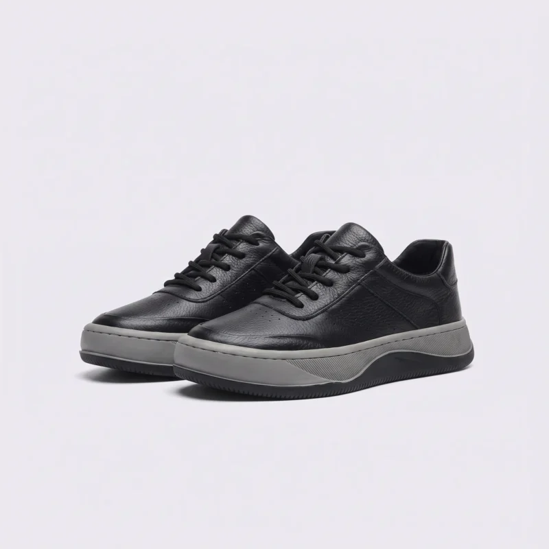 genuine leather casual sneakers breathable chunky sole in black, front 45-degree view of the pair on a light gray background
