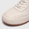 genuine leather casual sneakers breathable chunky sole in white, close-up view of the toe on a light gray background