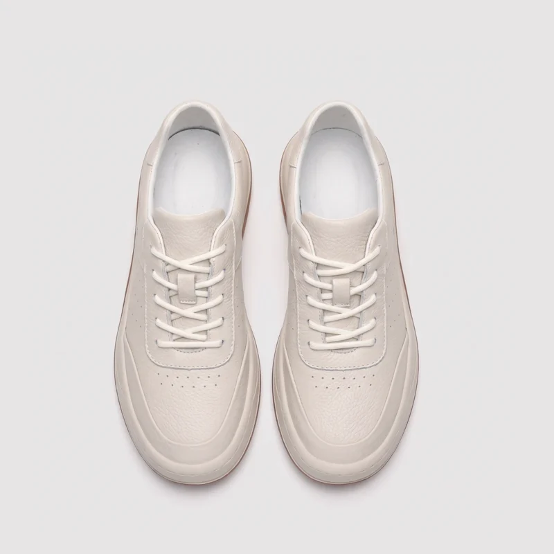 genuine leather casual sneakers breathable chunky sole in white, top-down view of the pair on a light gray background