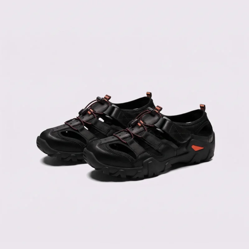 cut-out sport sandals - closed toe with hook-and-loop straps and a lugged rubber sole in black, front 45-degree view of the pair on a light gray background