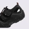 cut-out sport sandals - closed toe with hook-and-loop straps and a lugged rubber sole in black, close-up view of the heel on a light gray background