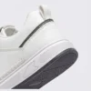 men's perforated slip-on sneakers - breathable knit casual walking shoes with cushioned sole in white, close-up view of the heel on a light gray background