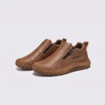 zip slip-on casual sneakers - lace-free smooth-upper shoes with a lugged thick sole in brown, front 45-degree view of the pair on a light gray background