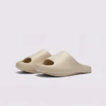 negative heel arch support slide sandals - thick platform one-piece eva slides for women in apricot, front 45-degree view of the pair on a light gray background