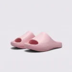negative heel arch support slide sandals - thick platform one-piece eva slides for women in pink, front 45-degree view of the pair on a light gray background