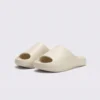 negative heel arch support slide sandals - thick platform one-piece eva slides for women in white, front 45-degree view of the pair on a light gray background