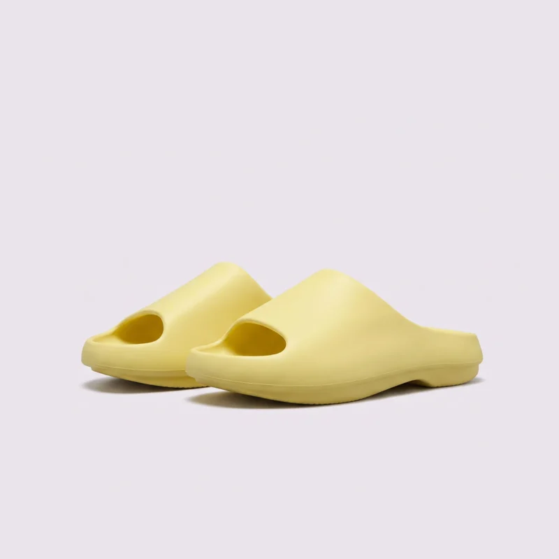 negative heel arch support slide sandals - thick platform one-piece eva slides for women, front 45-degree view of the pair on a light gray background