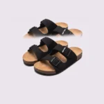 two-strap buckle casual sandals - adjustable double-strap slides with cushioned cork footbed for men and women in black, front 45-degree view of the pair on a light gray background