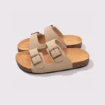 two-strap buckle casual sandals - adjustable double-strap slides with cushioned cork footbed for men and women in cream, front 45-degree view of the pair on a light gray background