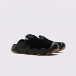 unisex wave-sole closed-toe clog slippers - suede slip-on mules with adjustable webbing strap and thick cushioned sole in black, front 45-degree view of the pair on a light gray background