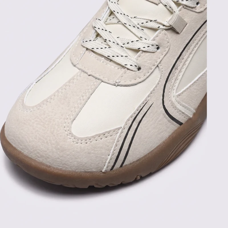 unisex wide-toe german trainer shoes - retro lace-up low-top sneakers in beige, close-up view of the toe on a light gray background