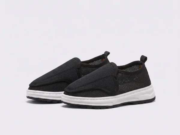 wide fit soft canvas slip-on shoes breathable mesh roomy toe everyday comfort in black, front 45-degree view of the pair on a light gray background