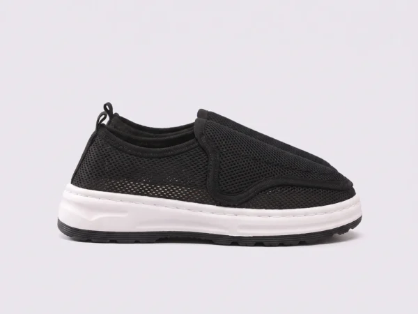 wide fit soft canvas slip-on shoes breathable mesh roomy toe everyday comfort in black, left side profile view on a light gray background