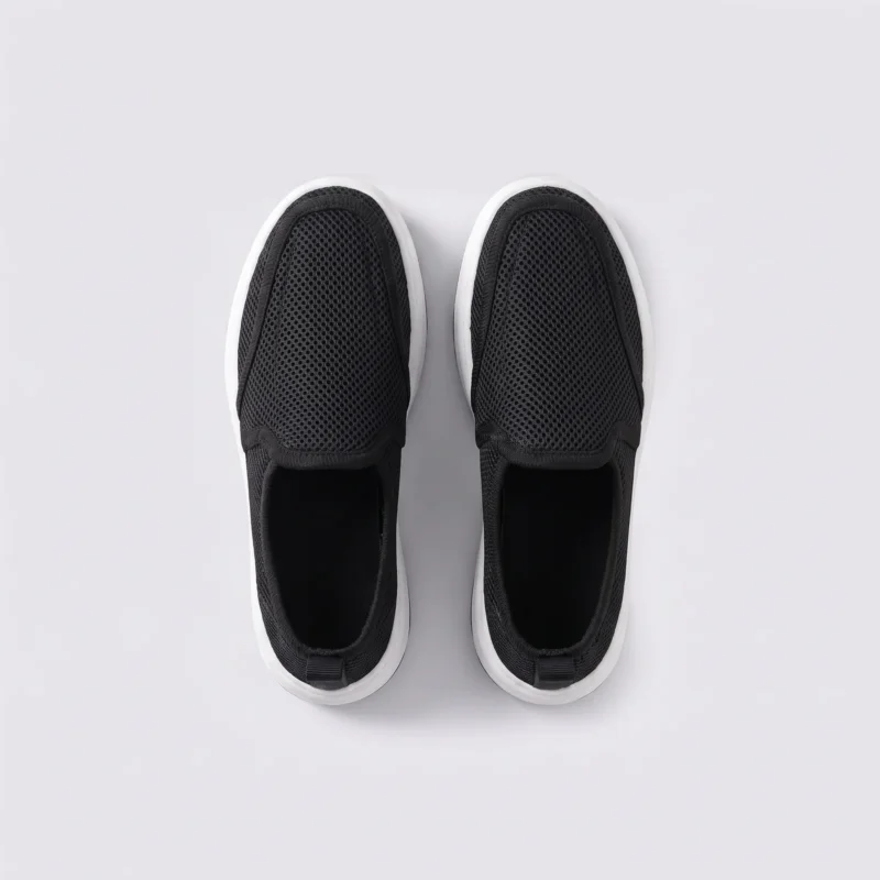 wide fit soft canvas slip-on shoes breathable mesh roomy toe everyday comfort in black, top-down view of the pair on a light gray background