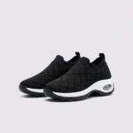 slip-on quilted sock sneakers - lace-free everyday shoes with a cushioned thick sole and heel window in black, front 45-degree view of the pair on a light gray background