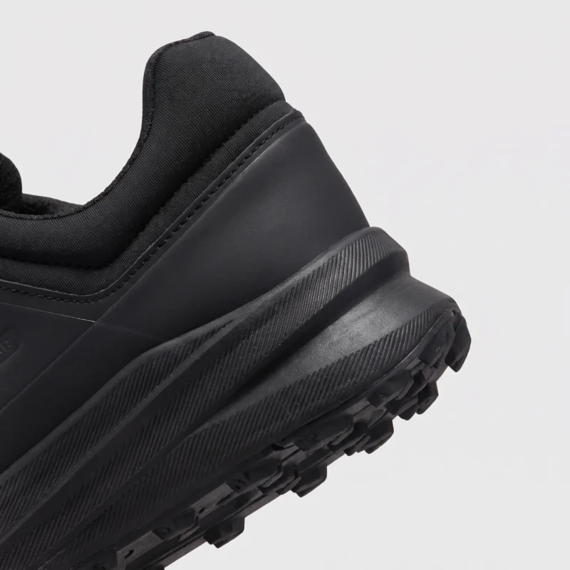boa closure hiking sneakers in black, close-up view of the heel on a light gray background