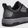 chunky sole leather casual sneakers in black, close-up view of the heel on a light gray background