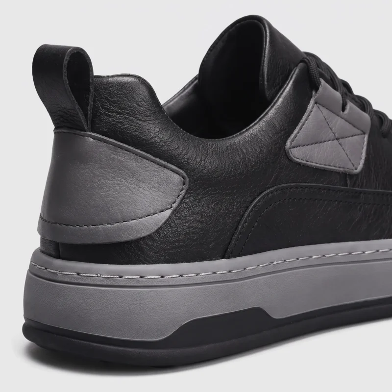 chunky sole leather casual sneakers in black, close-up view of the heel on a light gray background
