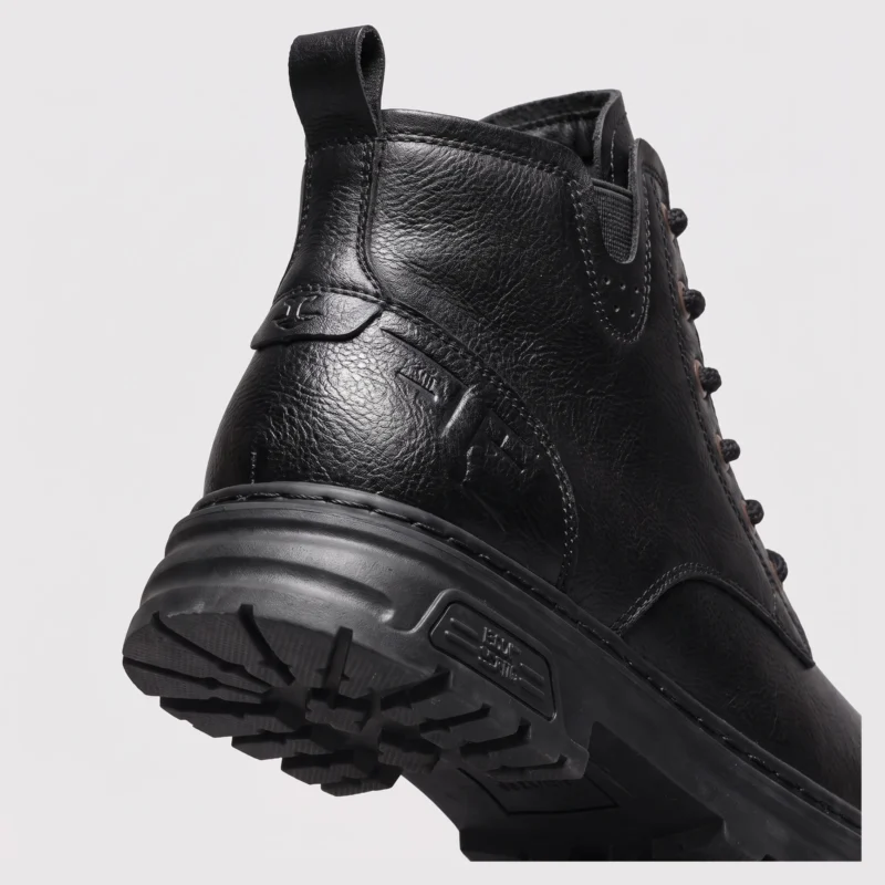 chunky sole leather ankle boots in black, close-up view of the heel on a light gray background