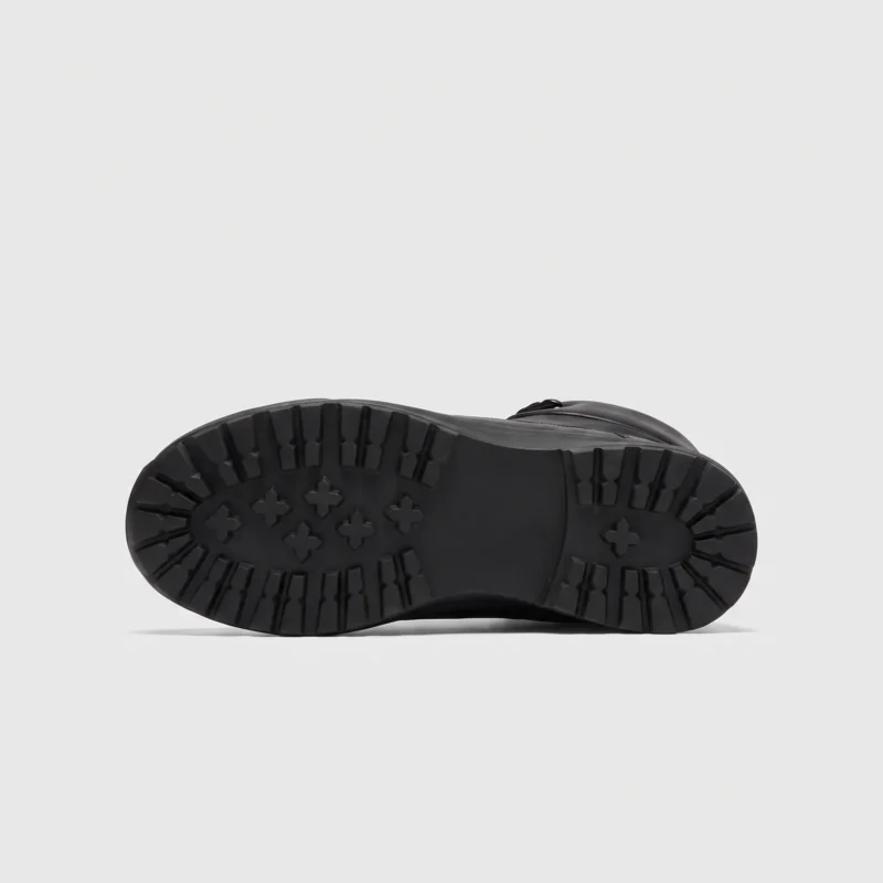 high-top leather boots in black, outsole tread view on a light gray background