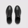 high-top leather boots in black, top-down view of the pair on a light gray background