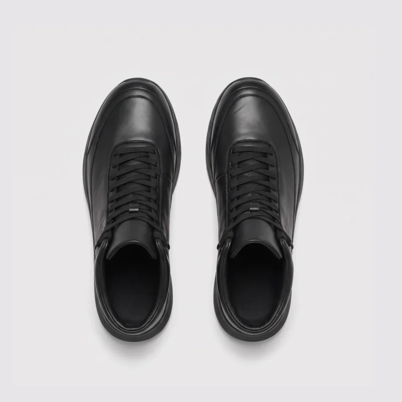 high-top leather boots in black, top-down view of the pair on a light gray background