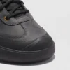 leather outdoor hiking sneakers in black, close-up view of the toe on a light gray background