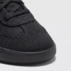 lightweight trail running sneakers in black, close-up view of the toe on a light gray background