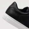 retro german trainer sneakers in black, close-up view of the heel on a light gray background