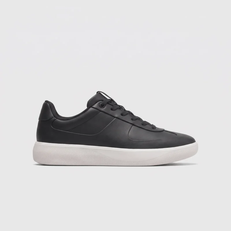 retro german trainer sneakers in black, right side profile view on a light gray background