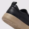 slip-on leather casual shoes in black, close-up view of the heel on a light gray background