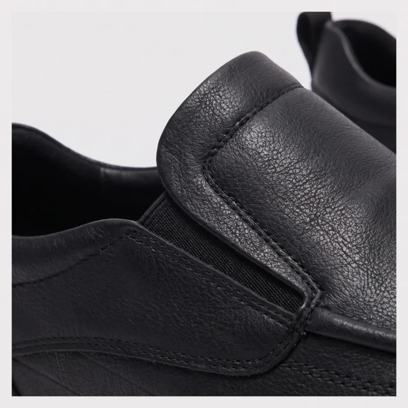 slip-on leather casual shoes in black, detail view on a light gray background