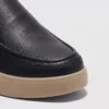 slip-on leather casual shoes in black, close-up view of the toe on a light gray background