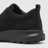 waterproof leather hiking sneakers in black, close-up view of the matte heel on a light gray background