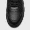 genuine leather casual shoes breathable lightweight non-slip walking sneakers in black, close-up view of the toe on a light gray background
