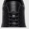 genuine leather business casual sneakers lightweight comfortable non-slip walking shoes in black, close-up view of the closure on a light gray background