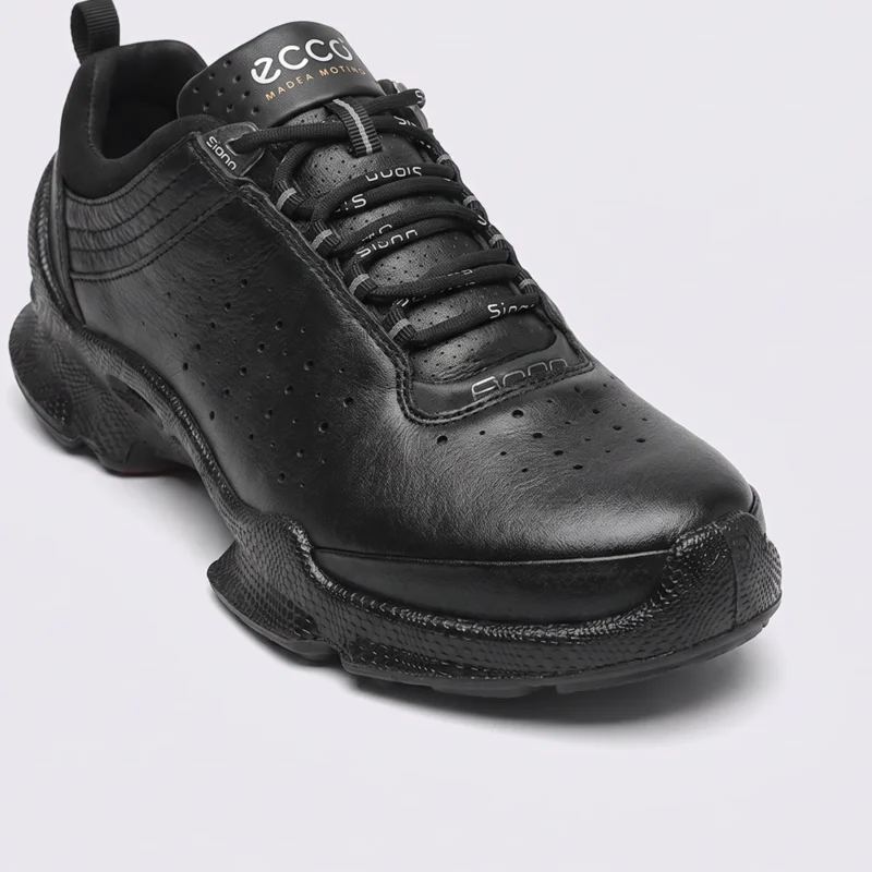 genuine leather business casual sneakers lightweight comfortable non-slip walking shoes in black, close-up view of the toe on a light gray background