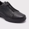 genuine leather business casual running sneakers in black, close-up view of the toe on a light gray background