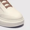genuine leather platform sneakers, close-up view of the toe on a light gray background