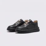 genuine leather platform sneakers in black, front 45-degree view of the pair on a light gray background