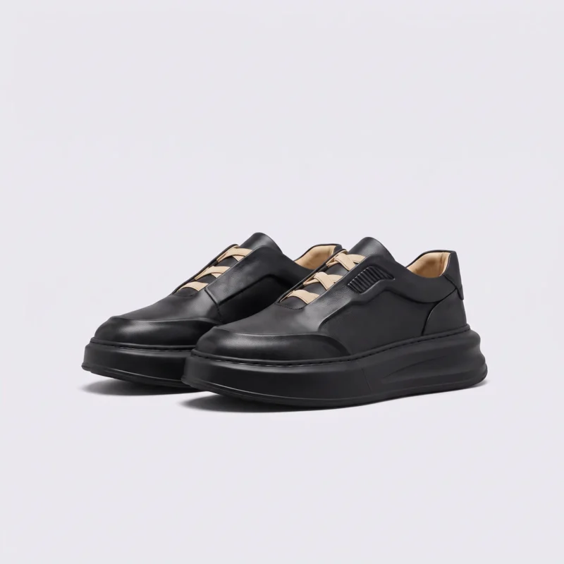 genuine leather platform sneakers in black, front 45-degree view of the pair on a light gray background
